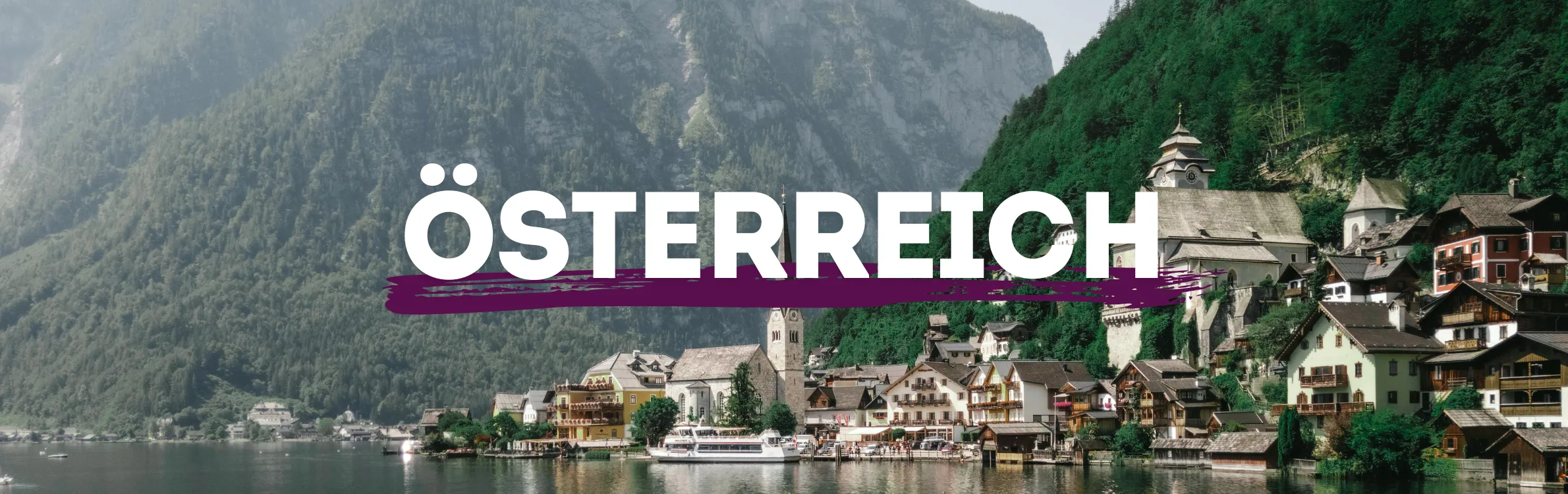 See in Österreich mit Fachwerkhäusern und Berge im Hintergrund